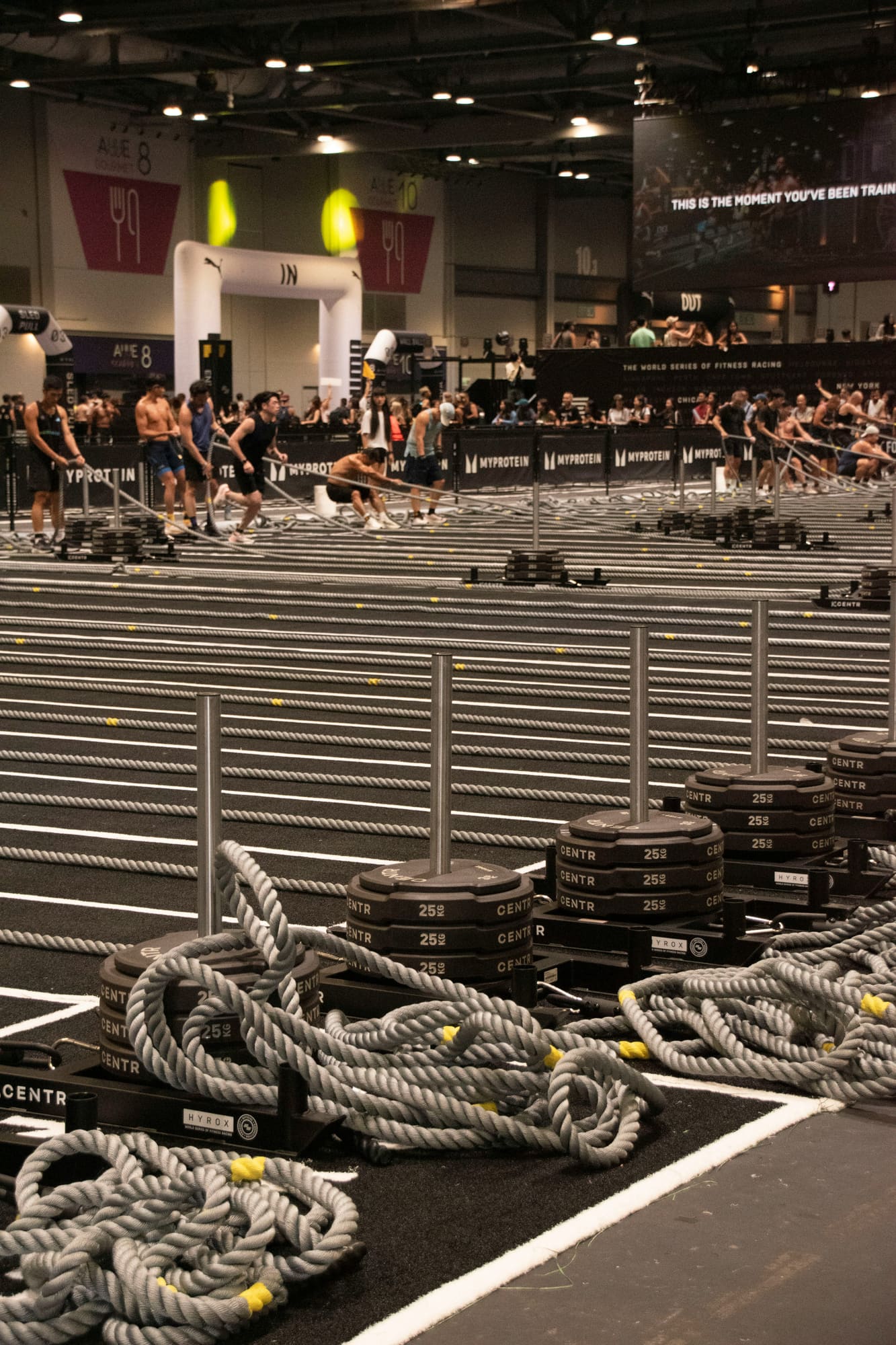 A fitness centre with rows of equipment and athletes mid-session