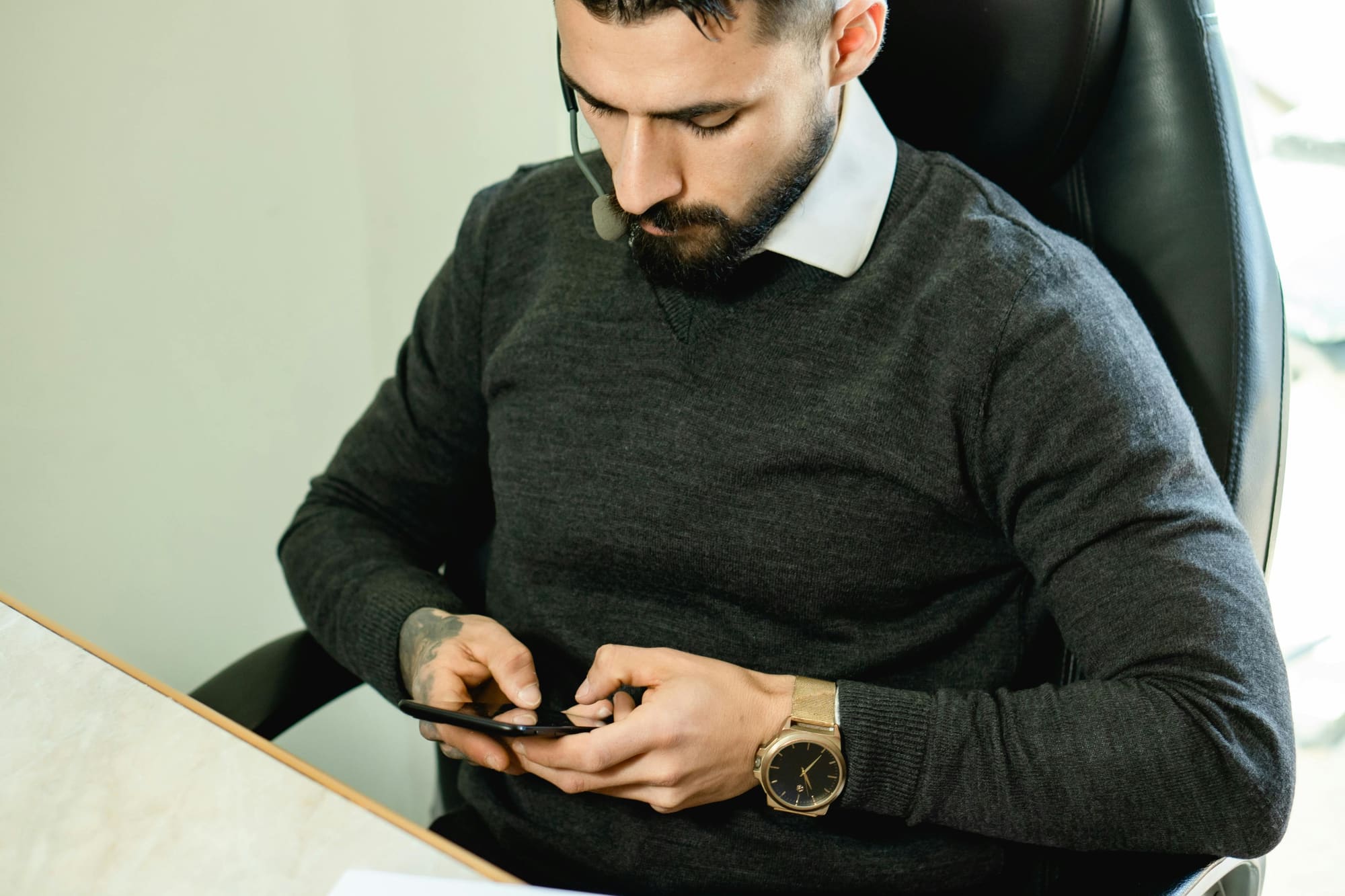 A person focused on a phone, mid-interaction