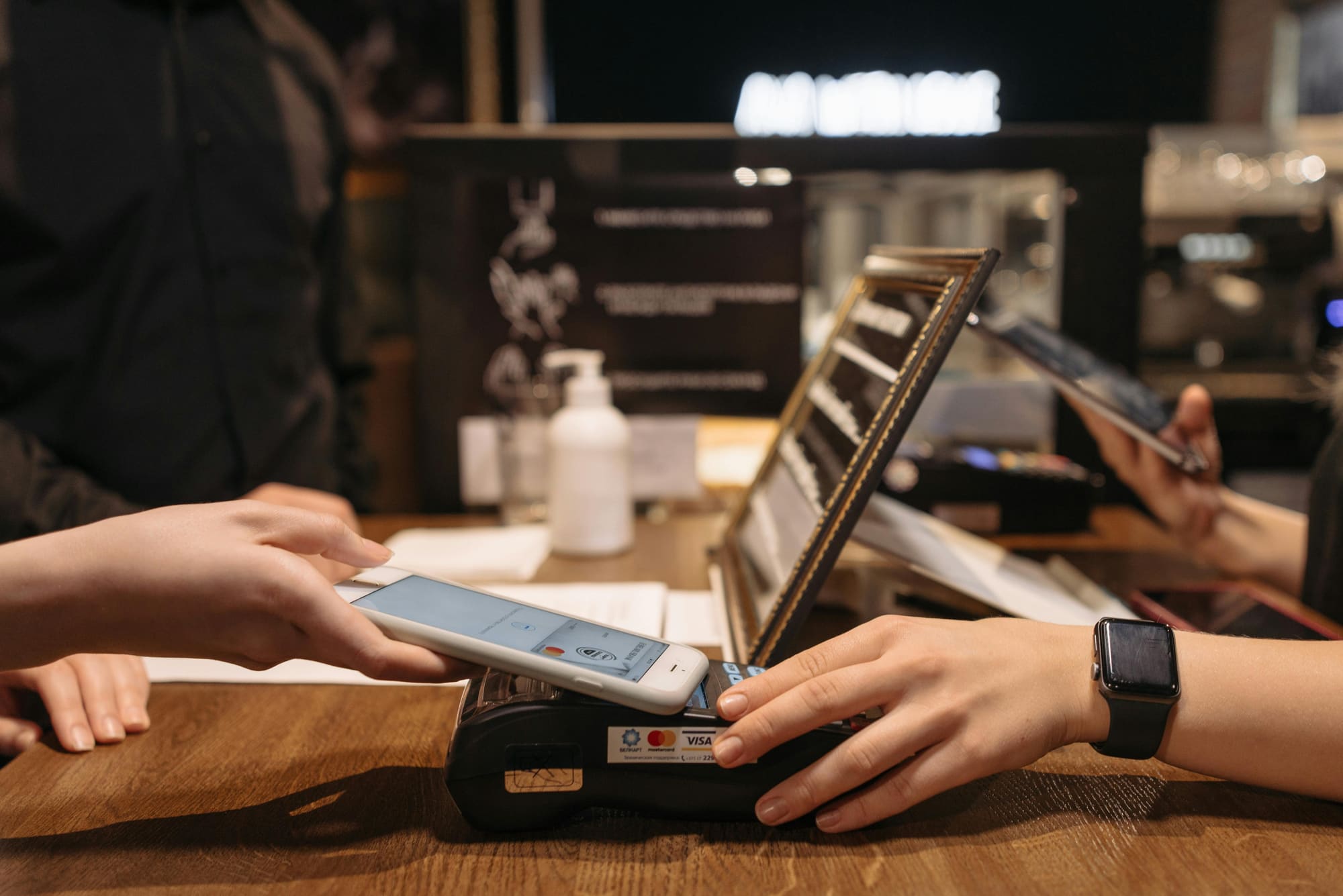 A phone tapping on a payment terminal at a hotel bar
