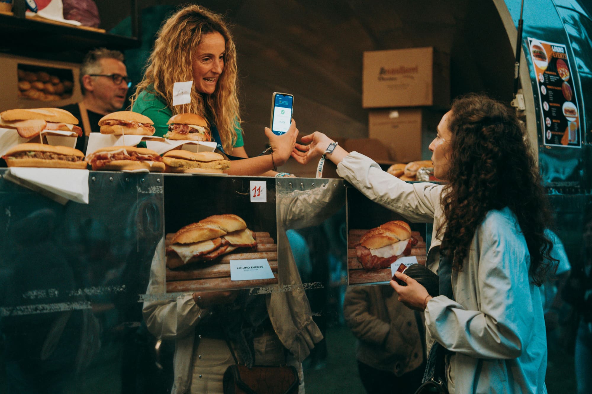 A customer showing a wallet pass to a vendor at a counter